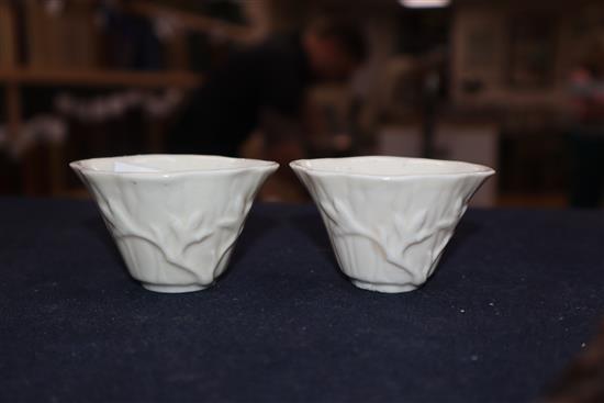 A pair of 18th century Chinese blanc de chine libation cups, wood stands